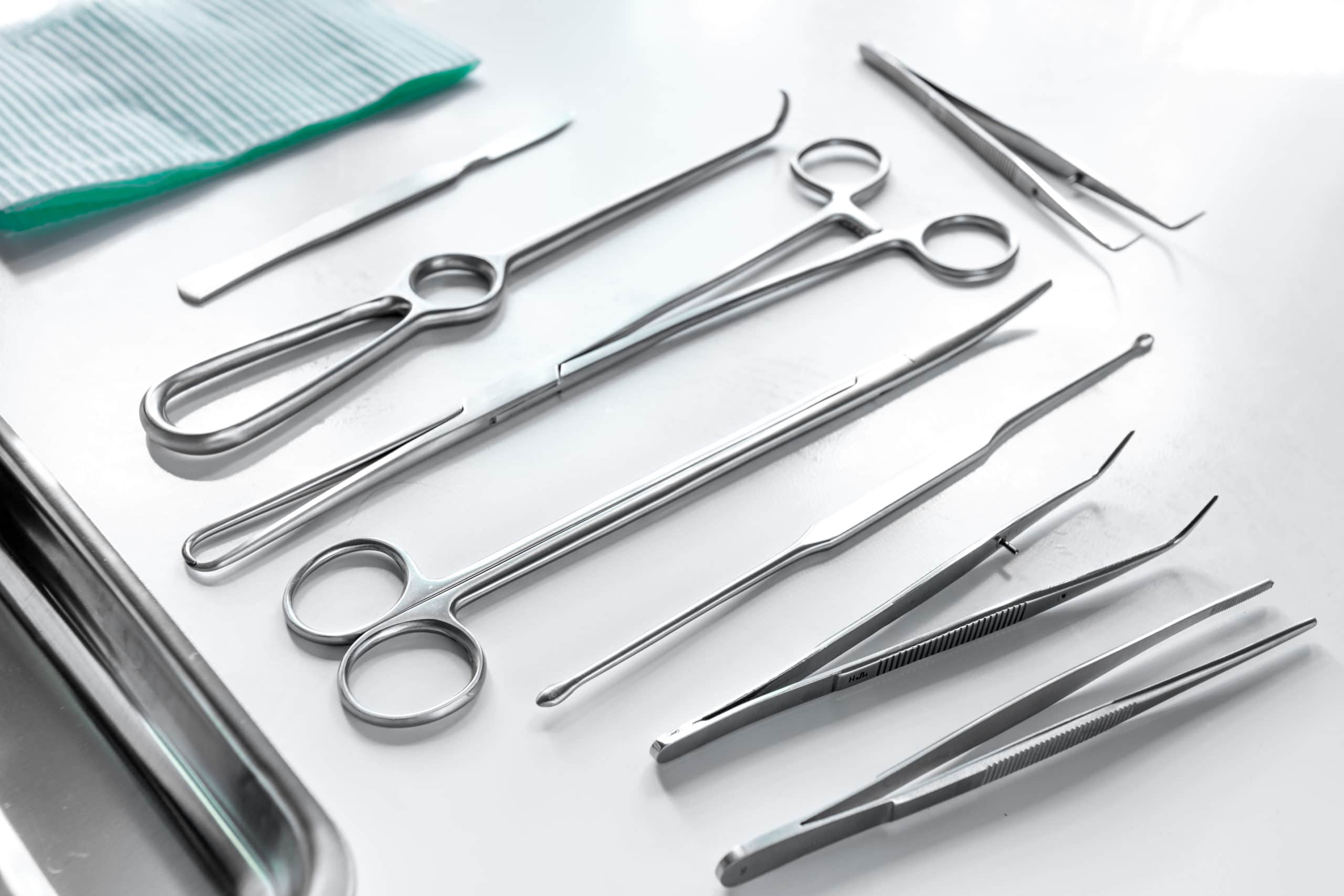 Medical instruments for plastic surgery on white backgrond top view copyspace.